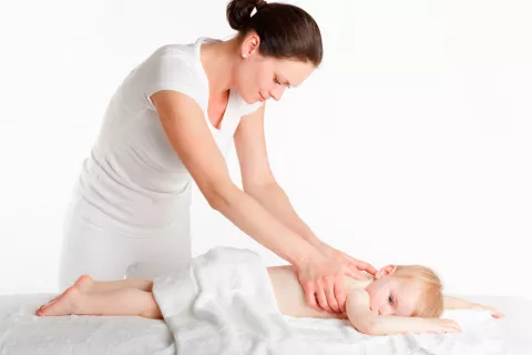 Fisioterapia infantil Experta en fisioterapia infantil trabajando con un bebé