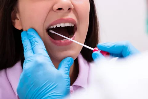Crean un test de saliva capaz de detectar cáncer de mama en 5 segundos Una mujer realizándose un test de saliva