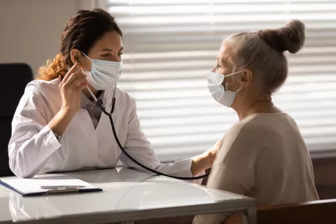 Fármacos para la artritis alivian ciertos síntomas del COVID persistente Doctora ausculta a una mujer con COVID persistente