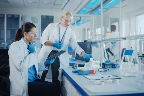 Dos científicas analizan muestras bioquímicas en un laboratorio